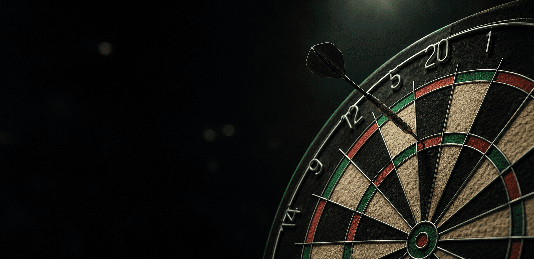 A dart embedded in a dartboard under dark arena lighting